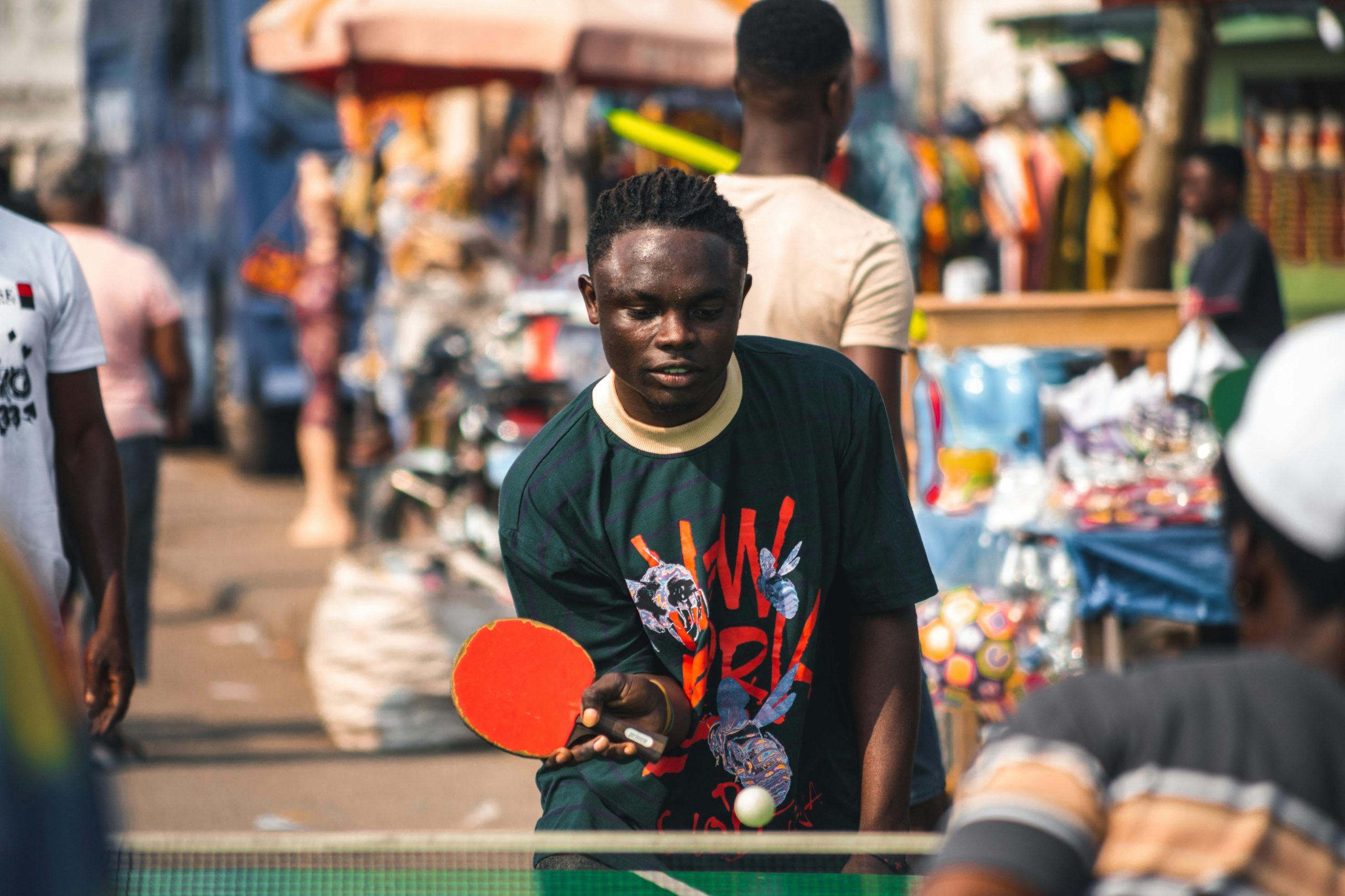 An outdoor street table tennis match in Accra, showcasing vibrant everyday life in Ghana.